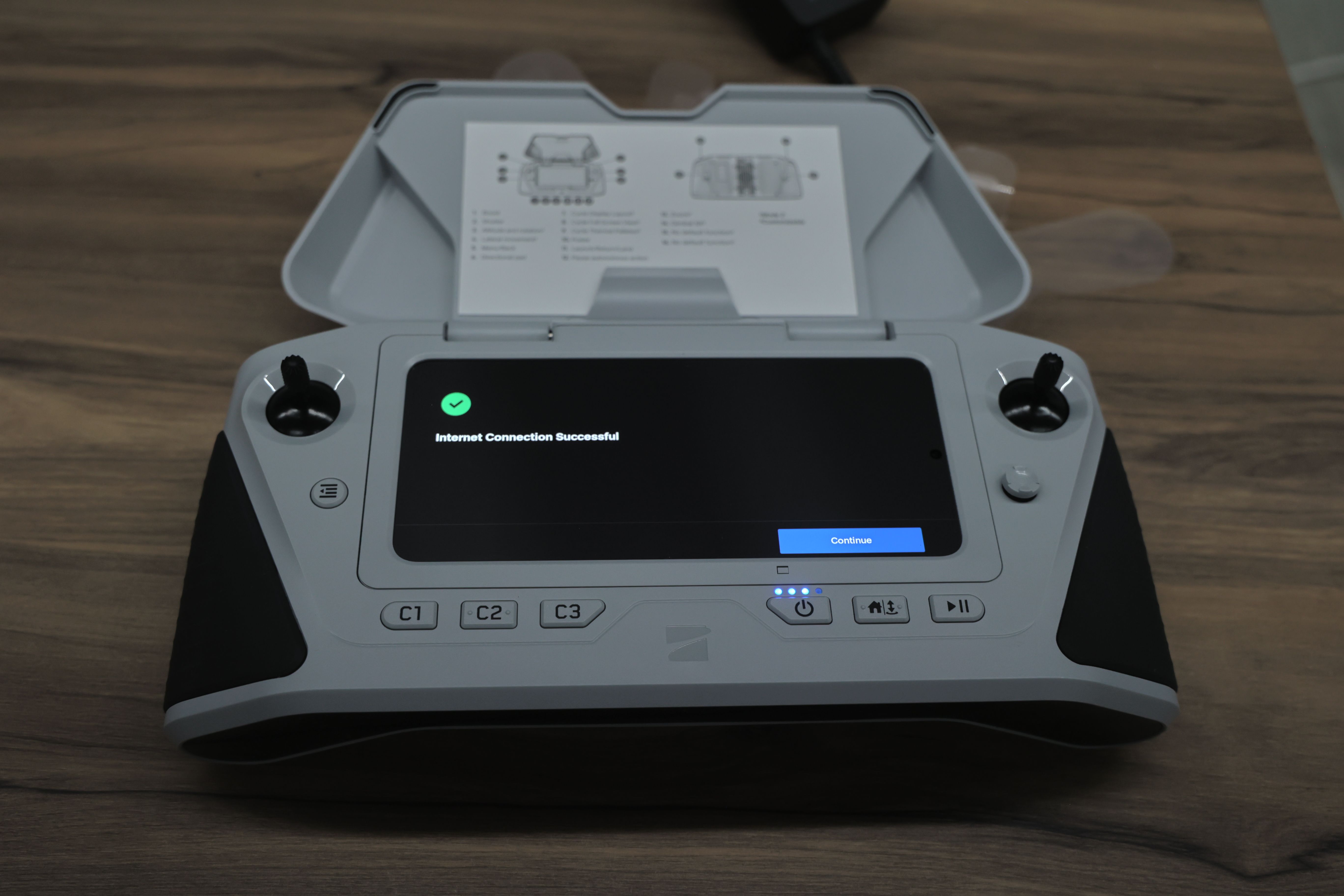 Skydio 無人機遙控器俯拍畫面，螢幕顯示「Internet Connection Successful」狀態訊息與確認圖示，裝置上可見雙搖桿、功能按鍵與展開的上蓋，整體放置於木質桌面上。